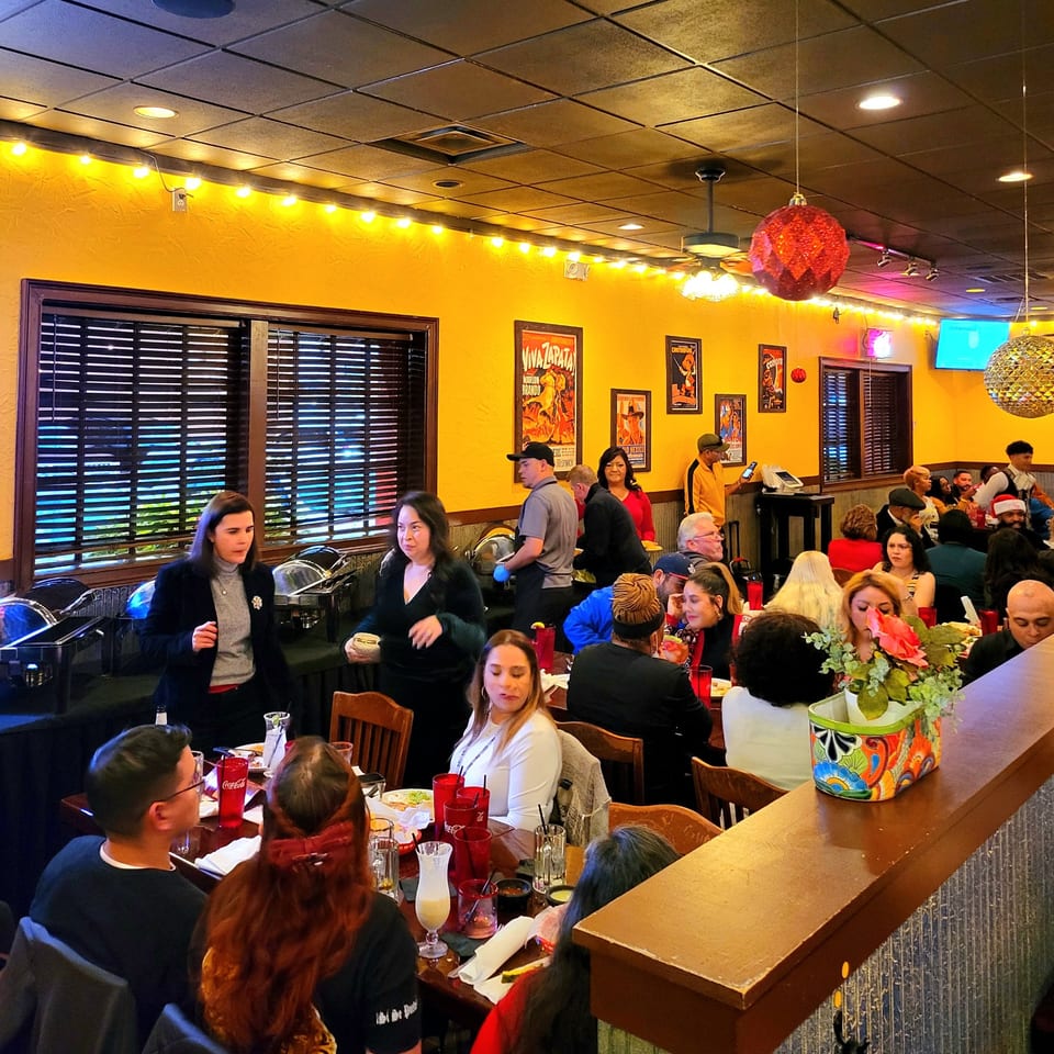 A lively Maria Rita's Tex-Mex restaurant interior with many patrons dining and staff working.