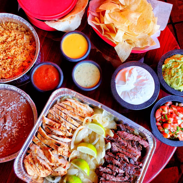 Maria Rita's Tex-Mex fajita family meal with chicken, steak, rice, beans, chips, and dips.