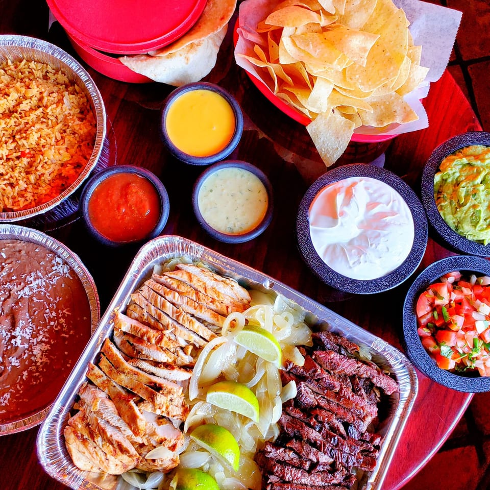 Maria Rita's Tex-Mex fajita family meal with chicken, steak, rice, beans, chips, and dips.
